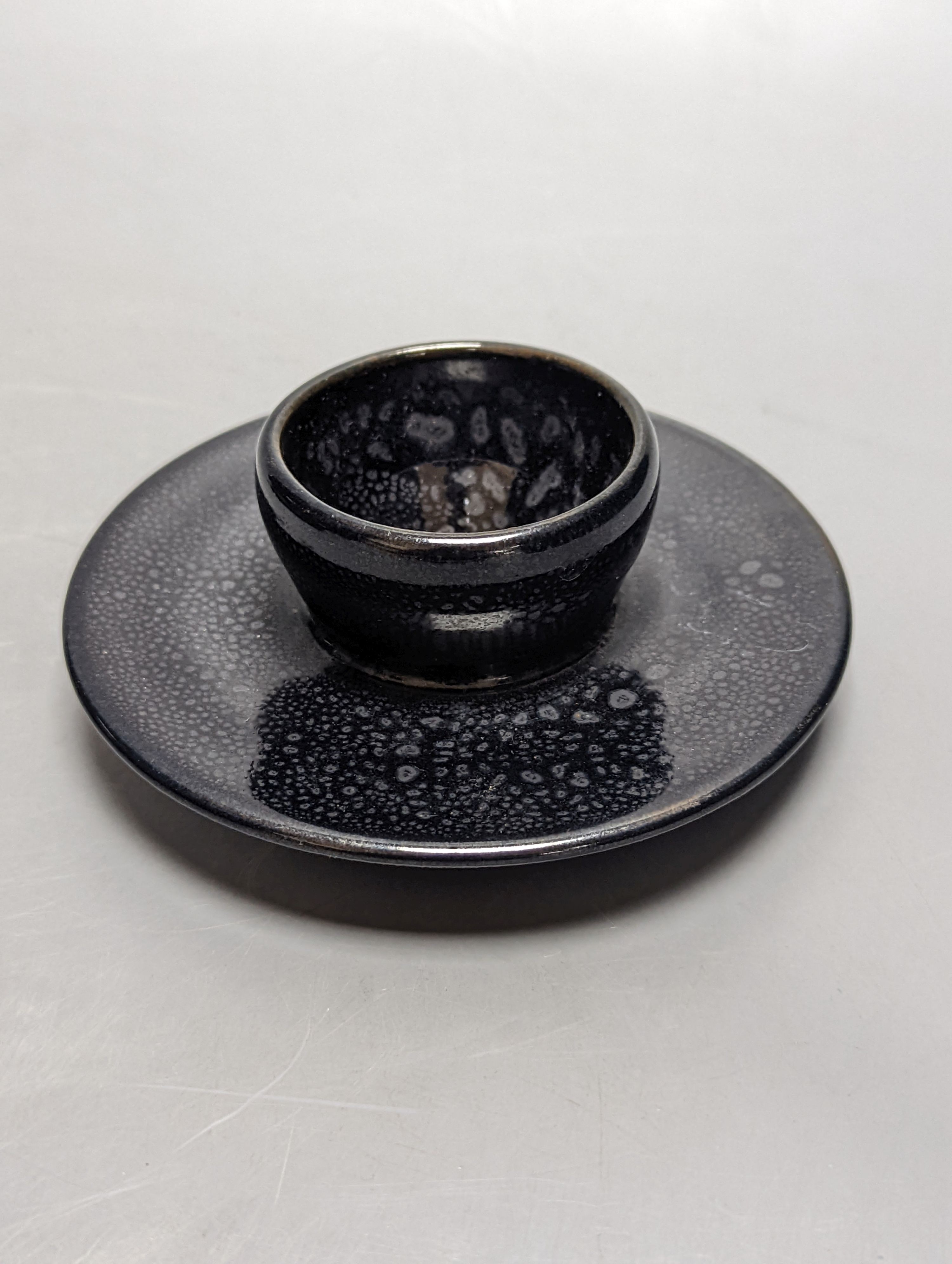 A Chinese oil spot glazed cup with integral stand and a black glazed resist pottery vase, 18cm